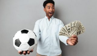 feliz-sorrindo-homem-africano-mostrando-notas-de-futebol-e-dinheiro